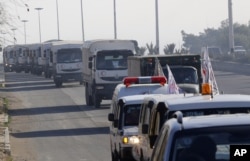 FILE - A convoy of trucks loaded with humanitarian supplies are seen heading to the besieged town of Madaya, 24 kilometers southwest of Damascus, Syria, for a U.N.-aid distribution, Jan. 14, 2016.