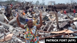 Survivants et parents inspectent les débris laissés par l'explosion meurtrière survenue dans le quartier de Mpila, à Brazzaville, le 5 mars 2012, dans un dépôt de munitions. L'incident avait fait plus de 200 morts et 1 000 blessés. 