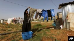 A Syrian refugee woman hangs laundry at a Syrian refugee camp in the eastern Lebanon on June 19, 2014.