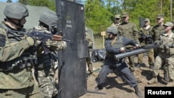 FILE - Ukrainian soldiers and servicemen of the U.S. Army's 173rd Airborne Brigade Combat Team take part in joint military exercises in Yavoriv, western Ukraine, May 12, 2015.