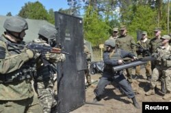 FILE - Ukrainian soldiers and servicemen of the U.S. Army's 173rd Airborne Brigade Combat Team take part in a joint military exercises in Yavoriv, outside Lviv, Ukraine, May 12, 2015.