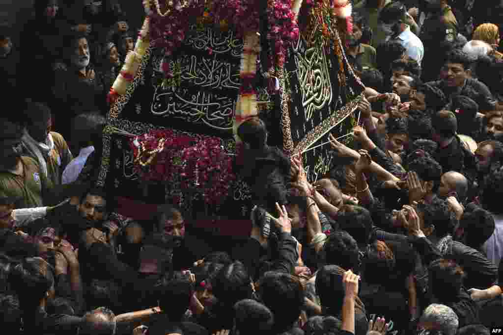 Shi'ite Muslim devotees take part in a religious procession to mark the 40th day of mourning after the anniversary of the death of Imam Hussain, the grandson of the Prophet Mohammed, in Lahore, Pakistan.