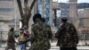 FILE - Taliban fighters walk toward journalists during a protest in Kabul on Dec. 28, 2021. 