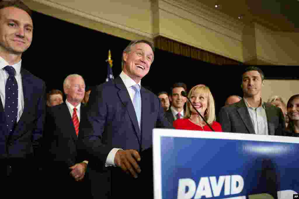 Georgia Republican U.S. Senate candidate David Perdue celebrates with outgoing U.S. Sen. Saxby Chambliss, R-Ga., left, and wife Bonnie, right, at his election night party, Tuesday, Nov. 4, 2014, in Atlanta.