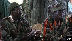 The leader of the Lord's Resistance Army, Joseph Kony , left, and his deputy Vincent Otti sit inside a tent Sunday 12, 2006 at Ri-Kwamba in Southern Sudan