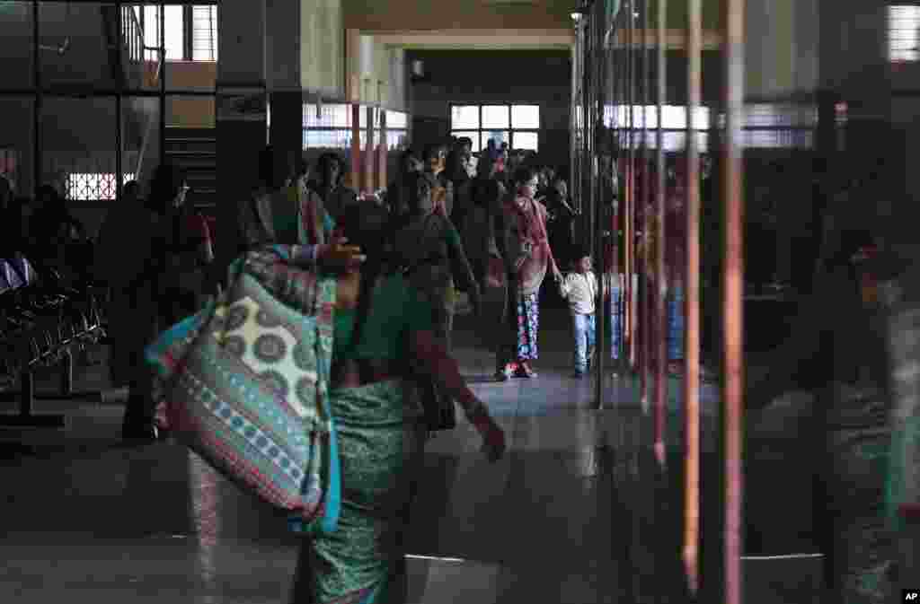 A pregnant Indian woman walks with a child in the corridor of the Modern Government Maternity Hospital in Hyderabad, India, Nov.12, 2014.