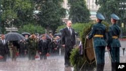 Tổng thống Nga Vladimir Putin đứng nghiêm dưới trời mưa to trong dịp tới viếng mộ chiến sĩ vô danh ở thủ đô Moscow hồi tháng Sáu.