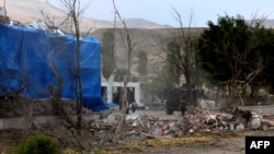 Wreckage lies on the ground in front of a Turkish military station covered by a tarpaulin after a suicide attack on August 2, 2015 in east Turkey town Dogubeyazit in Agri Province.