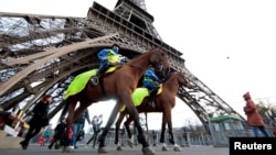 Mounted French Republican Guards patrol under the Eiffel Tower as the French capital remains under a high security alert following recent fatal shootings and ahead of the World Climate Conference 2015, in Paris, France, Nov. 28, 2015. 