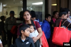 A mother seeking entry into the United States with her children in McAllen, Texas. (Photo: A Barros / VOA)
