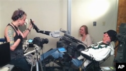 A quadriplegic research subject Tim Hemmes uses his thoughts to operate a robotic arm.