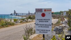 A warning sign stands at the entrance of the PDVSA/BOPEC Brasil Terminal in Rincon Bonaire on the Caribbean Netherlands island of Bonaire, May 7, 2018, where Venezuela refines and stores its heavy crude. 