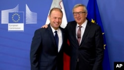 European Commission President Jean-Claude Juncker, right, welcomes Malta's Prime Minister Joseph Muscat prior to a meeting at EU headquarters in Brussels on Wednesday, Nov. 16, 2016. Malta will assume the EU rotating six month presidency as of Jan. 1, 2017.