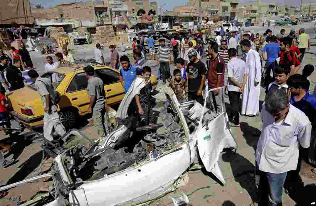 Iraqis inspect the aftermath of a car bomb attack in the Shi'ite enclave of Sadr City, Baghdad, July, 29, 2013. 