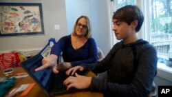 Jodi Smith Lemacks, left, works with her son, Joshua, in their home in Richmond, Va., Tuesday, Oct. 16, 2018. Lemacks is nervous about changing or losing her job because that could mean cutting off her son Joshua from heart specialists he’s seen his entire life. 