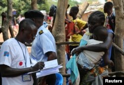 An official from the International Organization for Migration (IOM) collects data and registers a Congolese migrant who crossed from Angola at the Kamako border, Kasai province in the Democratic Republic of the Congo, Oct. 13, 2018.