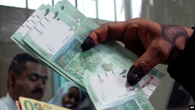 A woman displays Sudan's new currency at the central bank in Khartoum, Sudan, July 24, 2011. 