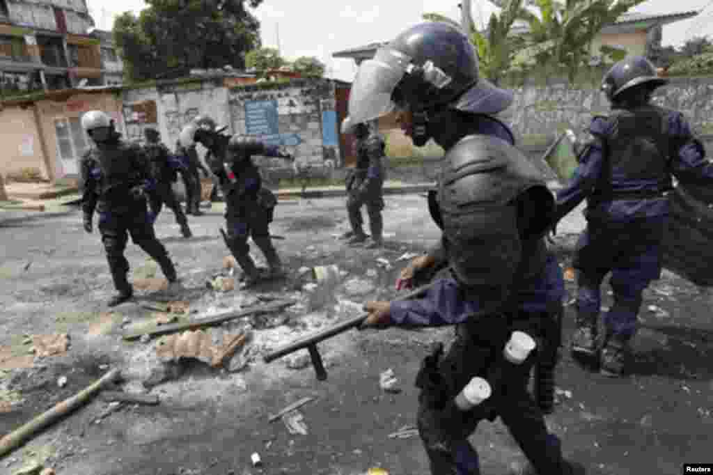 Riot police dismantle a roadblock in Democratic Republic of Congo's capital Kinshasa December 10, 2011. Clashes between opposition protesters and security forces broke out in parts of Democratic Republic of Congo on Saturday, killing at least one, a day a