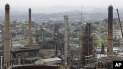 FILE - Chimneys from the Engen oil company are seen on the outskirts of the city of Durban, South Africa, Nov. 30, 2011.