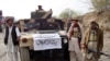 Armed militants of Tehreek-e-Taliban Pakistan (TTP) pose for photographs next to a captured armored vehicle in the Pakistan-Afghanistan border town of Landikotal on November 10, 2008, after they hijacked supply trucks bound for Afghanistan.