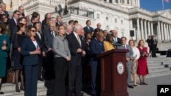 From left in front row, House Minority Leader Nancy Pelosi, D-Calif., former Rep. Gabby Giffords of Arizona who was shot in 2011, Rep. Mike Thompson, D-Calif., and civil rights leader Rep. John Lewis, D-Ga., lead House Democrats in a call for action on gun safety legislation on the House steps at the Capitol in Washington, Oct. 4, 2017. 