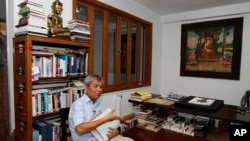 In this July 2, 2014 photo, Director of Documentation Center of Cambodia Youk Chhang holds Poch Younly's dairy book during an interview with the Associated Press, in Phnom Penh.