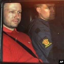 Norway's twin terror attacks suspect Anders Behring Breivik, left, sits in an armored police vehicle after leaving the courthouse following a hearing in Oslo, July 25, 2011