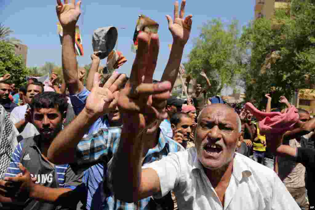 Pro-government supporters of Prime Minister Nouri al-Maliki, chant slogans during a demonstration in Baghdad, Aug. 13, 2014.