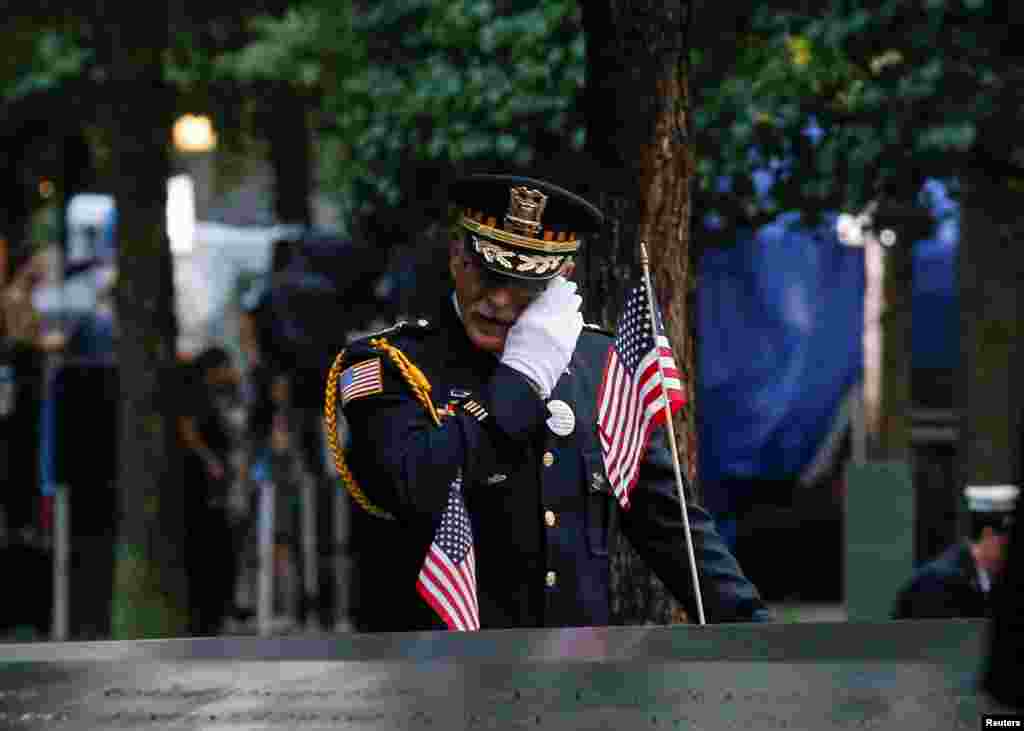 A guest wipes tears at the south reflecting pool of the National 9/11 Memorial and Museum during ceremonies marking the 17th anniversary of the September 11, 2001 attacks on the World Trade Center in New York, Sept. 11, 2018.