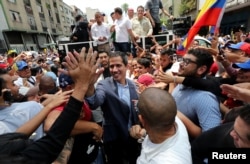 Venezuelan opposition leader Juan Guaido, whom many nations have recognized as the country's rightful interim ruler, greets supporters during a rally in Los Teques, Venezuela, March 30, 2019.