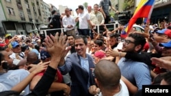 Venezuelan opposition leader Juan Guaido, whom many nations have recognized as the country's rightful interim ruler, greets supporters during a rally in Los Teques, Venezuela, March 30, 2019. 