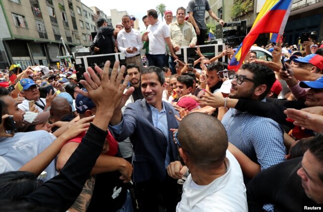 Venezuelan opposition leader Juan Guaido, whom many nations have recognized as the country's rightful interim ruler, greets supporters during a rally in Los Teques, Venezuela, March 30, 2019.