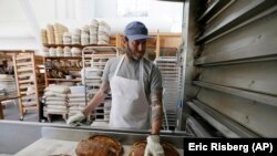 Nothing beats warm bread and butter! In this photo, baker Chad Robertson checks loaves of bread coming out of an oven at the Tartine Manufactory in San Francisco, California, 2017. (AP Photo/Eric Risberg)