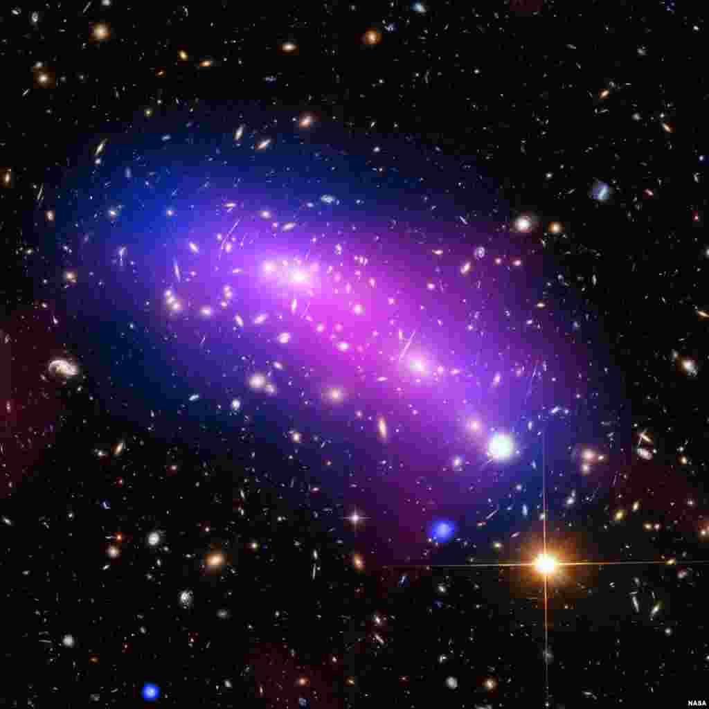 Một đám mây nhiều màu sắc, đánh dấu địa điểm va chạm của hai cụm thiên hà hình thành một vật thể duy nhất được biết đến với cái tên MACS J0416.1-2403, được nhìn thấy trong một bức hình không đề ngày tháng của NASA, kết hợp dữ liệu từ ba kính viễn vọng khác nhau.