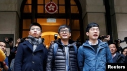 Pro-democracy activists (L-R) Joshua Wong, Alex Chow and Nathan Law pose outside the Court of Final Appeal before a verdict on their appeal in Hong Kong, Feb. 6, 2018. 