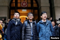 Pro-democracy activists, left to right, Joshua Wong, Alex Chow and Nathan Law pose outside the Court of Final Appeal before a verdict on their appeal in Hong Kong, China, Feb. 6, 2018.