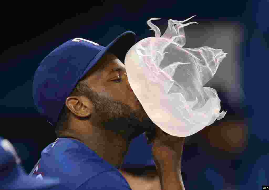 កីឡាករ Hanser Alberto ពាក់លេខ ២ របស់ក្រុម Texas Rangers ផ្លុំស្ករកៅស៊ូ នៅអំឡុងពេលប្រកួតកីឡាវាយកូនបាល់ MLB ជាមួយនឹងក្រុម Toronto Blue Jays កាលពីថ្ងៃទី០៤ ខែឧសភា ឆ្នាំ២០១៦ នៅឯកីឡាដ្ឋាន Rogers Center នៅក្រុង Toronto រដ្ឋ Ontario ប្រទេសកាណាដា។