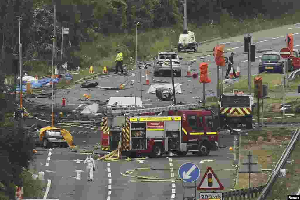 Emergency services and crash investigation officers work at the site where a Hawker Hunter fighter jet crashed onto the A27 road at Shoreham near Brighton, Britain. A jet aircraft ploughed into several cars on a busy road near an airshow in southern England, killing at least seven people, police said.