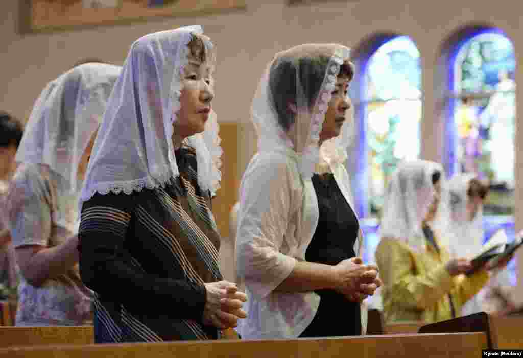 People pray for victims of the 1945 atomic bombing during a mass at the Urakami Cathedral in Nagasaki on the 68th anniversary of the bombing of the city, August 9, 2013. (Reuters/Kyodo)