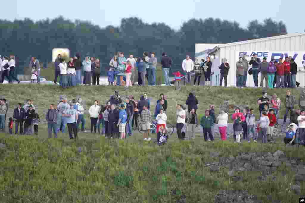 People stand on the south bank of the Skagit River to watch the rescue operation following Interstate 5 bridge collapse, Mount Vernon, Washington, May 23, 2013.