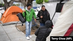 Members of the San Francisco Homeless Outreach Team talk to a homeless person in the Mission District, Sept. 10, 2024, in San Francisco. (AP Photo/Terry Chea)