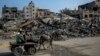 Palestinos montan una carreta tirada por un burro junto a edificios destruidos durante los ataques israelíes en Beit Lahia, en el norte de Gaza. Foto tomada el 26 de febrero de 2024, en medio de continuas batallas entre Israel y el grupo militante palestino Hamás.