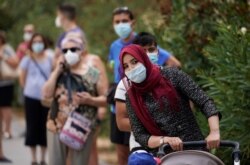 People queue for tests outside Federica Montseny primary health care center during the coronavirus pandemic in Madrid, Spain, Aug. 20, 2020.