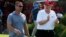 FILE - President Donald Trump walks with Gene Gibson, commanding officer at Coast Guard Station Lake Worth Inlet, as he arrives, Dec. 29, 2017, to meet with members of the U.S. Coast Guard, who he invited to play golf, at Trump International Golf Club, in West Palm Beach, Fla. 