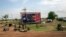 Civilians preparing to flee from renewed attacks gather in front of a sign celebrating the second anniversary of South Sudan's independence in Bentiu, Unity state of South Sudan, April 20, 2014.