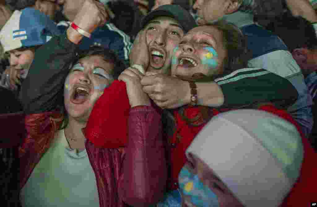 Argentina soccer fans react with jubilation as they watch their team defeat the Netherlands, via a live broadcast of the World Cup semifinal match on an outdoor screen in Buenos Aires, Argentina, July 9, 2014.