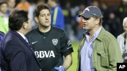 FILE - In this May 14, 2015, photo, Argentine businessman Alejandro Burzaco (R) is seen talking to a soccer official and a goalkeeper at a stadium in Buenos Aires, Argentina.