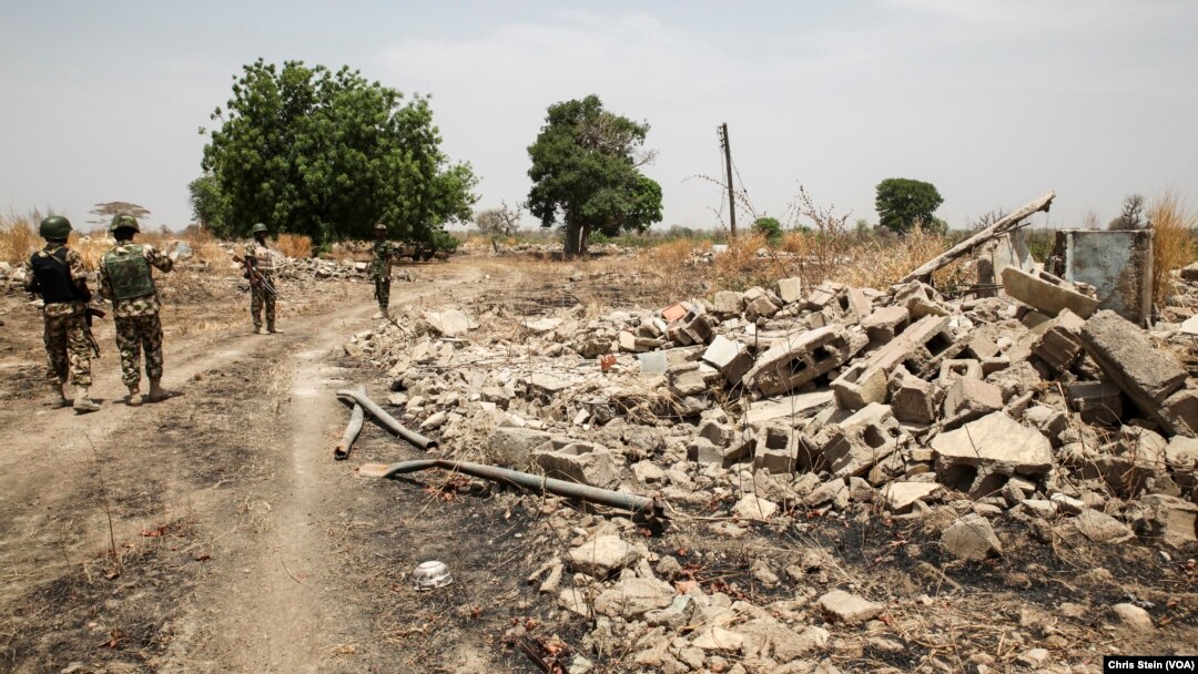 Soldiers walk among the ruins of the Government Secondary School in Chibok, Nigeria, March 25, 2016.