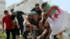 Demonstrators spray water on a man who tried to self-immolate himself during a protest demanding the removal of Algeria&#39;s ruling elite, in Algiers.