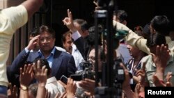 Pakistan's former President Pervez Musharraf (L) salutes his supporters as he leaves after his appearance before the district High Court in Karachi March 29, 2013. The Sindh High Court on Friday granted a bail extension to Musharraf, local media reported.